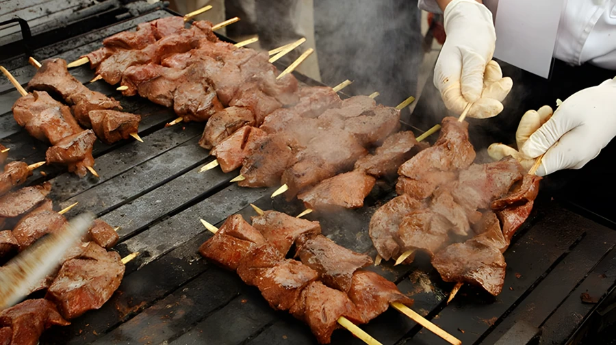 Tourists eating traditional street food anticuchos in downtown Cusco
